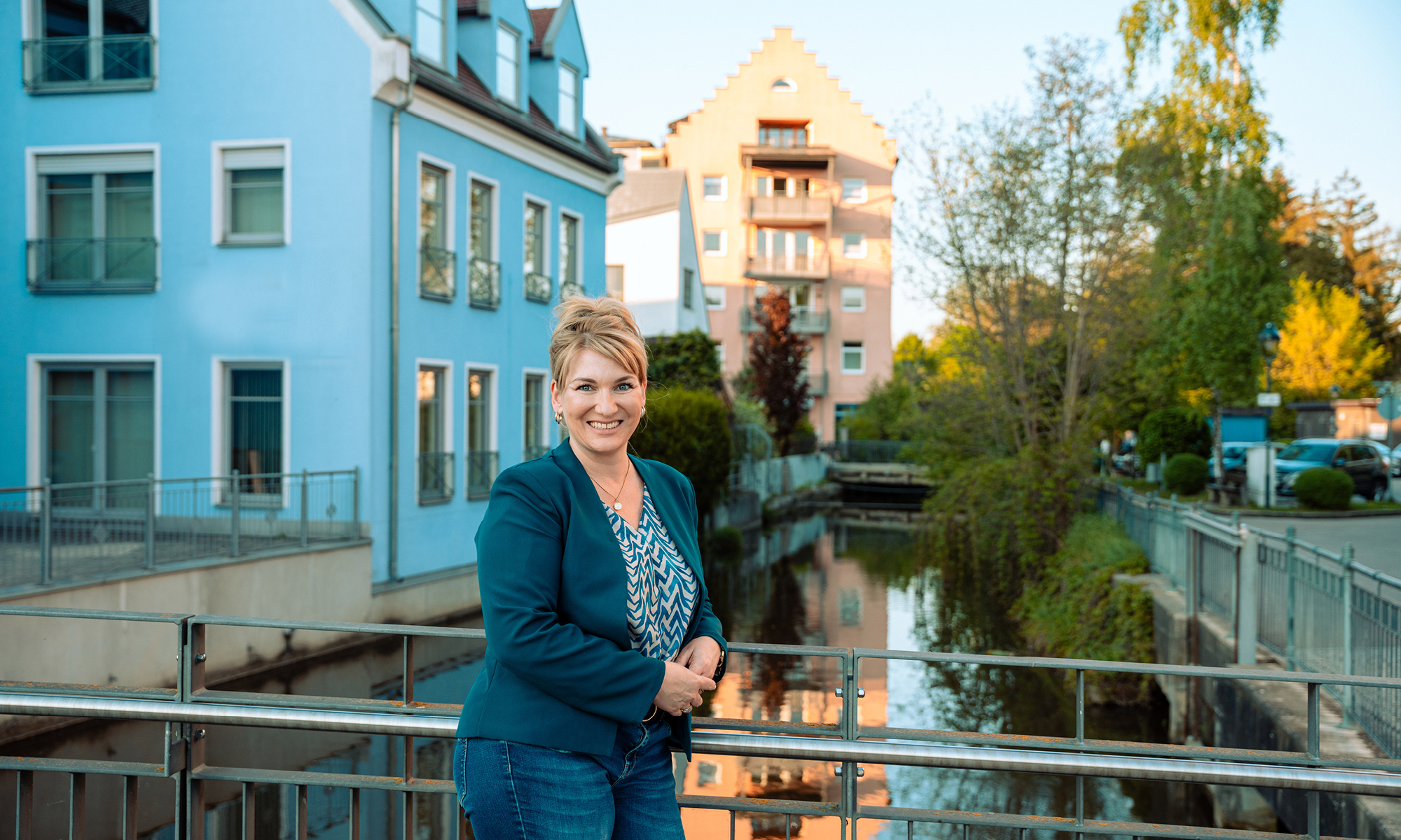 Verena Beese steht am Geländer der Wertinger Zusambrücke. Im Hintergrund ist das Gebäude der Stadtmühle zu sehen.
